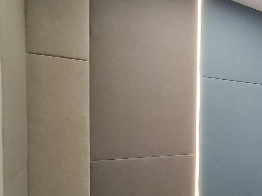 Fabric-wrapped wall panels in beige and pale blue, separated by a slim vertical light line