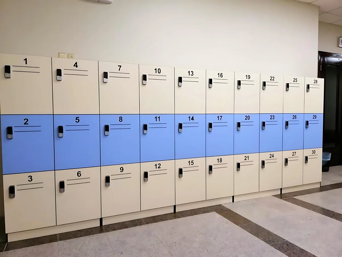 Bank of cream lockers with a blue middle row, numbered doors and an electronic keypad lock on each door