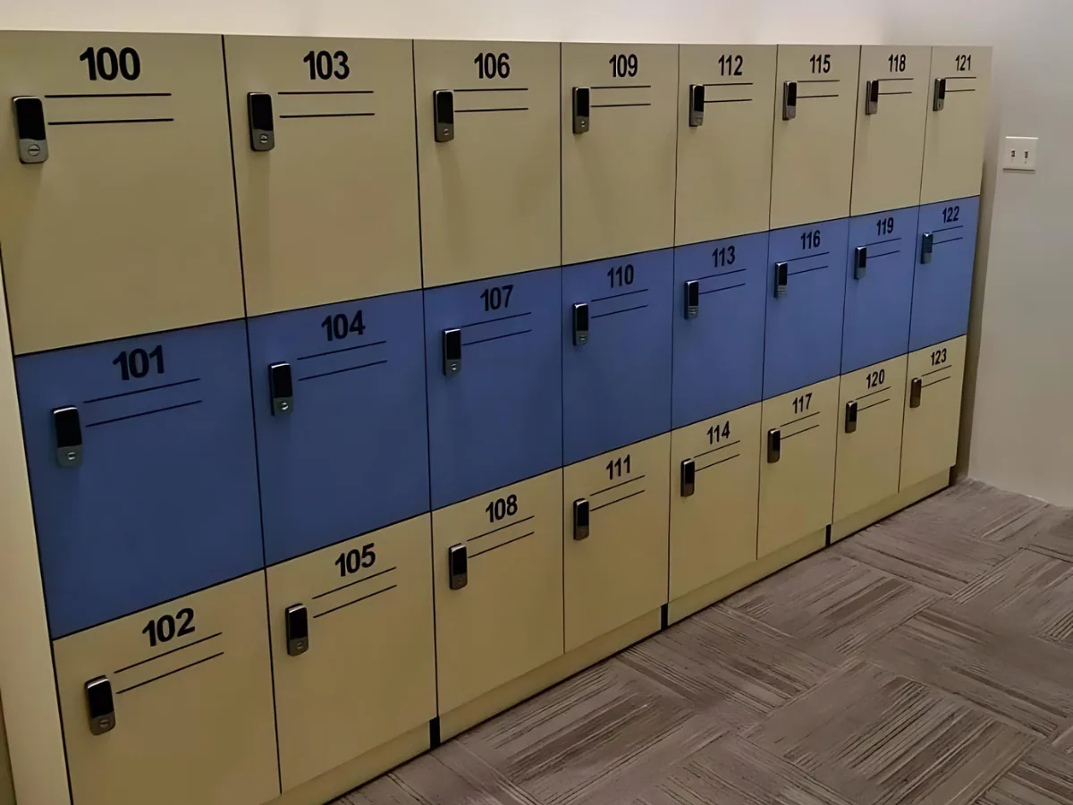 Three-tier locker bank with electronic locks over carpet-tile flooring